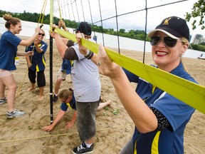 H.O.P.E. Executive Director Holly Tarrison (R) smiles as members of her event staff install a net at Mooney's Bay Beach as preperations for the HOPE VOLLEYBALL SUMMERFEST continue. The world's largest beach volleyball event takes place on Saturday July 12th. 
Errol McGihon/Ottawa Sun/QMI Agency