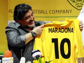 Al Wasl's head coach Diego Maradona of Argentina looks at a jersey given to him by club chairman Marwan Bin Bayat during a news conference in Dubai, September 11, 2011. (REUTERS/Jumana El Heloueh)