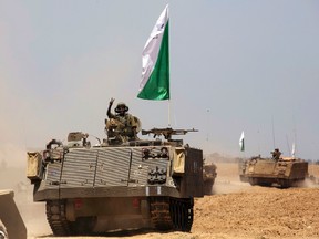 An Israeli soldier from the Nahal Infantry Brigade gestures on top of an armoured personnel carrier (APC) across a field near central Gaza Strip July 12, 2014.  REUTERS/Baz Ratner