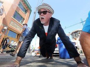 Ward 6 City Councillor Scott McKeen takes part in a push-up flash mob at the 104 Street Farmers Market, in Edmonton Alta., on Friday July 11, 2014. The push-up flash mob was organized to raise awareness about the a 1 million push-up challenge that will be held September 20, 2014 at Edmonton Expo Centre. David Bloom/Edmonton Sun/ QMI Agency
