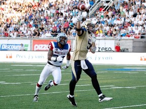 Drew Willy #5 of the Winnipeg Blue Bombers passes the ball while being chased by Kyries Hebert #34 of the Montreal Alouettes during the CFL game at Percival Molson Stadium on July 11, 2014 in Montreal, Quebec, Canada.