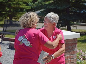 Jan Frith smiles after getting a hug from Oldman Rose Society president Ianthe Goodfellow. The society members spent five years working on the rose garden at Lebel Mansion in Pincher Creek. The Celtic cross shaped garden boasts 55 different hardy Canadian rose plants. John Stoesser photos/QMI Agency.