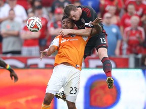 Toronto FC captain Steven Caldwell heads the ball away from a Houston Dynamo player on Saturday. (USA TODAY SPORTS)