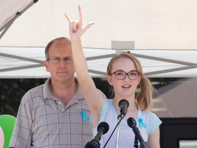 Cassidy Stay stands with her grandfather Roger Lyon (L) as she addresses the crowd during a memorial service for members of the Stay family who were murdered in their home Wednesday, in Spring, Texas July 12, 2014. (REUTERS/Dan Kramer)