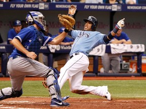 Rays shortstop Yunel Escobar (right) slides home and tagged by Blue Jays catcher Josh Thole and called out during the sixth inning in St. Petersburg, Fla., on Sunday. Upon review, the out was overturned and Escobar was credited with a run. (Kim Klement/USA TODAY Sports)