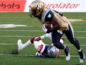 Clarence Denmark of the Winnipeg Blue Bombers dodges a tackle by Geoff Tisdale of the Montreal Alouettes during the CFL game at Percival Molson Stadium on July 11, 2014 in Montreal, Quebec, Canada. (Richard Wolowicz/Getty Images/AFP)