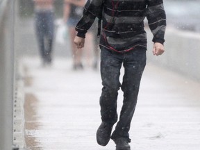 Pedestrians caught in a rain shower cross the Maryland Bridge in Winnipeg today.  Saturday,  July 12, 2014. (Chris Procaylo/Winnipeg Sun/QMI Agency)