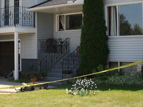 A candle memorial is set up in front of the home as Calgary city police sift through articles in the garage on Saturday July 12, 2014 of the home where five-year-old Nathan O'Brien and his grandparents Alvin and Kathryn Liknes went missing in Parkhill in SW Calgary, Alta. Stuart Dryden/Calgary Sun/QMI Agency