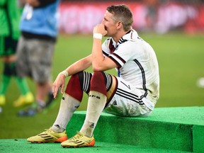 Germany's Bastian Schweinsteiger sits and rests after winning the World Cup trophy at the end of their 2014 World Cup final against Argentina at the Maracana stadium in Rio de Janeiro July 13, 2014. (REUTERS/Dylan Martinez)