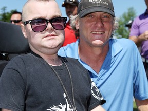 Retired Toronto Blue Jays third baseman Kelly Gruber poses with Phil "Hot Wheelz" Cook of Trenton, Ont. at the Medigas Celebrity Classic golf tournament Saturday, Jul 12, 2014 in Belleville, Ont. Gruber, former Jay Al Woods and more than two dozen other professional athletes helped raise $122,200 for local youth. Luke Hendry/Belleville Intelligencer/QMI Agency