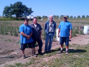 Rob Day, centre left, and Sandy Singers, centre right, from the Partners in Mission Food Bank are flanked by two inmates from Collins Bay who helped plant more than an acre of vegetables for the food bank. Submitted photo