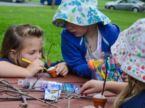 Campers from the Camp Trillium summer day camp sit at a picnic bench in City Park to take part in arts and crafts. (Alex Pickering/For The Whig-Standard