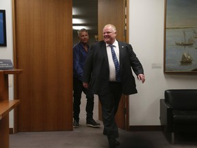 Mayor Rob Ford (R) and his sobriety coach Bob Marier exit the inner office to the mayor's office on their way to council meeting Thursday July 10, 2014. (Jack Boland/Toronto Sun)