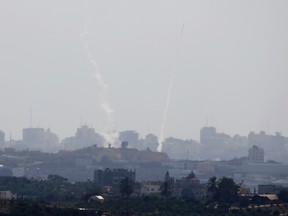A smoke trail and a rocket (R) are seen as the rocket is fired from the northern Gaza Strip towards Israel July 15, 2014.   REUTERS/Baz Ratner