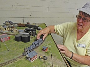 Oil Museum of Canada intepreter Jackie South, wearing a railway engineer's hat, gets a close look at the display's rolling stock. The exhibit will be on display at the museum's Black Gold Festival on July 20.            
SUBMITTED PHOTO/ QMI AGENCY