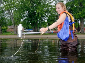 Student public health inspector Sarah de Jonge collects water for testing Monday at Tweed Memorial Park. Inspectors collect beach water using a pole fitted with a bottle and a thermometer, then send the water to a lab to measure its E. coli bacteria count. 
Luke Hendry/The Intelligencer