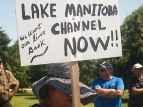 A Lake Manitoba resident holds up a sign demanding an emergency outlet be built on Lake Manitoba immediately. About 80 farmers and residents came to protest at Mark Peters' farm, which is at the farthest end of the Portage Diversion, on Tuesday regarding the province's announcement it will take seven years to build an emergency oulet for the lake. (Svjetlana Mlinarevic/The Graphic/QMI Agency)