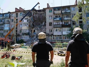 Rescuers work at a shattered five-storey building, which was damaged by a recent shelling, in the eastern Ukrainian town of Slaviansk July 16, 2014. Fighting raged in Ukraine's east on Wednesday when separatists tried to break through the lines of government forces near the border with Russia and a tentative step towards agreeing conditions for a ceasefire failed. REUTERS/Gleb Garanich
