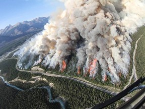 Spreading Creek wildfire burns along Highway 11 that boarders the Banff National Park border in Alberta is seen from an aircraft. The blaze was sparked by lightning and has consumed over 5,630 hectares, closed campgrounds and blanketed parts of southern and central Alberta with smoke.  If residents who have any health concerns related to the smoke are directed to call Alberta Health Link at 1-866-408-LINK (5465). Photo Supplied by/Alberta Environment and Sustainable Resources