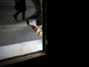 A vagrant begs at the entrance of a church in the Andalusian capital of Seville March 5, 2012.  REUTERS/Marcelo del Pozo (SPAIN - Tags: SOCIETY TPX IMAGES OF THE DAY)