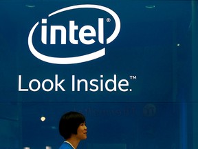An employee walks past an Intel logo during the 2014 Computex exhibition at the TWTC Nangang exhibition hall in Taipei June 3, 2014.  REUTERS/Pichi Chuang