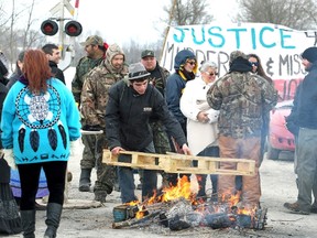 First Nation's bands form a blockade at the main VIA rail line between Toronto and Ottawa near Marysville, Ontario March 19, 2014. The blockade was part of a day of action to call attention to missing and murdered indigenous and aboriginal women. (REUTERS/Fred Thornhill)