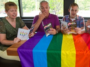 Deb Al-Hamza, Martin Withenshaw, Andrew Rosser and Chad Callander ham it up with the Pride Festival program in London, Ont. on Wednesday July 16, 2014. Al-Hamza is the parade director, Whithenshaw a past president, Rosser is the current President of the festival and Callander is the VP of the Pride Festival that runs this weekend. (MIKE HENSEN, The London Free Press)