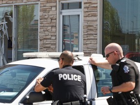 Edmonton Police Service officers investigate after a violent break-in in at HELM Property Management near 156 Street and Stony Plain Road in Edmonton, Alta., on Monday, July 14, 2014. Ian Kucerak/Edmonton Sun