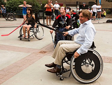 Progressive Conservative leadership candidate Thomas Lukaszuk tries wheelchair ball hockey during the Five Hole for Food ball hockey tournament at Centennial Plaza in Edmonton, Alta., on Wednesday, July 16, 2014. The aim of the tournament is to gather donations for local food banks. Edmonton is the 11th stop out of 13 on this year's tour. Codie McLachlan/Edmonton Sun/QMI Agency