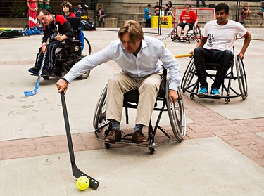 Progressive Conservative leadership candidate Thomas Lukaszuk tries wheelchair ball hockey during the Five Hole for Food ball hockey tournament at Centennial Plaza in Edmonton, Alta., on Wednesday, July 16, 2014. The aim of the tournament is to gather donations for local food banks. Edmonton is the 11th stop out of 13 on this year's tour. Codie McLachlan/Edmonton Sun/QMI Agency