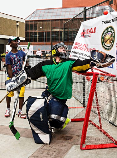 Jenny Scrivens makes a save while taking a turn in net during the Five Hole for Food ball hockey tournament at Centennial Plaza in Edmonton, Alta., on Wednesday, July 16, 2014. The aim of the tournament is to gather donations for local food banks. Edmonton is the 11th stop out of 13 on this year's tour. Codie McLachlan/Edmonton Sun/QMI Agency
