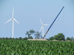 A crane swings over the wind turbine construction site in Lambton Shores, where the $400-million Jericho Wind Energy project is under construction. Turbines from an older, and smaller, wind project near Kettle Point can be seen in the background. The 92-turbine Jericho project is the largest in Lambton, so far. PAUL MORDEN/THE OBSERVER/QMI AGENCY