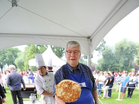 Premier David Hancock flips some pancakes during the premier's pancake breakfast at the Alberta Legislature in Edmonton, Alberta on July 17, 2014. (Perry Mah/Edmonton Sun/QMI Agency)