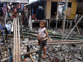 A girl stands amidst debris on a makeshift bamboo bridge after Typhoon Rammasun (locally named Glenda) hit a coastal village of sea gypsies (locally known as Badjaos) in Batangas city, south of Manila, July 17, 2014.  

REUTERS/Erik De Castro