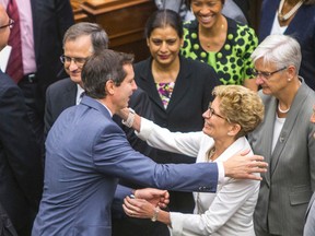 Ontario Premier Kathleen Wynne embraces her predecessor Dalton McGuinty after the throne speech at Queen's Park in Toronto on Thursday, July 3, 2014. (Ernest Doroszuk/Toronto Sun)