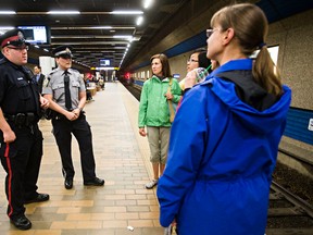 Cst. Jon Holven, left, and transit peace officer Chantel Deboer chat with LRT patrons during a press conference to discuss a joint initiative between Edmonton police and Edmonton Transit to promote security on Edmonton’s LRT network at Churchill LRT Station in Edmonton, Alta., on Thursday, July 17, 2014. Codie McLachlan/Edmonton Sun