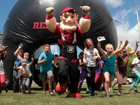A Ottawa RedBlacks rally was held at city hall in Ottawa Thursday July 17,  2014. A couple hundred people gathered to cheer on their football team before Friday's home opener. Big Joe running with some fans Thursday.  Tony Caldwell/Ottawa Sun/QMI Agency