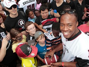 A Ottawa RedBlacks rally was held at city hall on Thursday July 17,  2014. A couple hundred people gathered to cheer on their football team before the July 18 home opener. RedBlacks quarterback Henry Burris signing autographs for the fans Thursday. 
Tony Caldwell/Ottawa Sun/QMI Agency