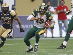 Edmonton Eskimos QB Mike Reilly scrambles for a first down during CFL action against the Winnipeg Blue Bombers at Investors Group Field in Winnipeg, Man., on Thu., July 17, 2014. Kevin King/Winnipeg Sun/QMI Agency