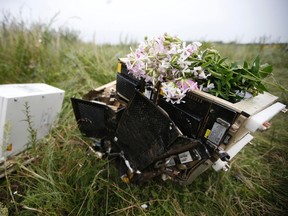 Flowers lie on debris from a Malaysian Airlines Boeing 777 plane which was downed on Thursday near the village of Rozsypne, in the Donetsk region on July 18, 2014. (REUTERS/Maxim Zmeyev)