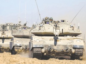 Israeli Merkava tanks deploy near Israel?s border with the Gaza Strip on Thursday. John Lloyd says Jews everywhere are held responsible by large numbers of non-Jews in Western democratic countries for Israeli actions. (Jack Guez/afp photo)