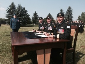Incoming 3rd Canadian Division Commander Brig.-Gen. Wayne Eyre, Canadian Army Commander Lt.-Gen. Marguis Hainse and promoted Maj.-Gen. Christan Juneau pose for a photo as command is signed over from Juneau to Eyre during a ceremony at Winston Churchill Park at the Edmonton Garrison on Friday, July 18, 2014. (Matt Dykstra/Edmonton Sun/QMI Agency)
