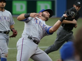 Rangers’ J.P. Arencibia, playing first base, catches a foul ball in the third inning at the Rogers Centre last night. The former Blue Jays’ catcher hit a three-run home run in the seventh inning off of R.A Dickey. (AFP)