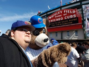 The real Cubs mascot poses with fans outside Wrigley Field in Chicago in this 2012 file photo. (REUTERS)