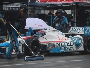 A member of James Hinchcliffe's pit crew uses a squeegee to clean off the track on Saturday at the Honda Indy. (Jack Boland, Toronto Sun)