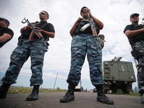 Armed pro-Russian separatists stand guard at a crash site of Malaysia Airlines Flight MH17, near the village of Hrabove, Donetsk region July 20, 2014.REUTERS/Maxim Zmeyev