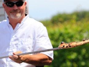 Richard Clarke, owner of Vintage Pizza Pie, serves up some pies to visitors to Sandbanks Estate Winery's food fair Saturday. The event featured local food vendors and producers with items paired up with wines by Sandbanks.
Emily Mountney/The Intelligencer/QMI Agency