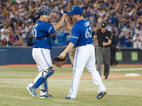 Toronto Blue Jays catcher Dioner Navarro (30) celebrates with relief pitcher Aaron Loup (62) at the end of a game against the Texas Rangers at Rogers Centre. The Toronto Blue Jays won 9-6. (Nick Turchiaro-USA TODAY Sports)