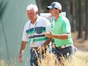 Rory McIlroy (R) of Northern Ireland talks with his dad Gerry McIlroy (L) prior to the tournament. (Andrew Redington/Getty Images/AFP)