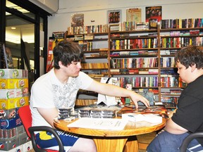 Kalin Brown (l) shows Cameron Holloway (r) some of the more intricate details of the fantasy card game Magic: The Gathering at Little Big Fort on Saturday, July 19. Brown will be teaching people how to play the game at Little Big Fort six days a week throughout the summer.
Barry Kerton | Whitecourt Star